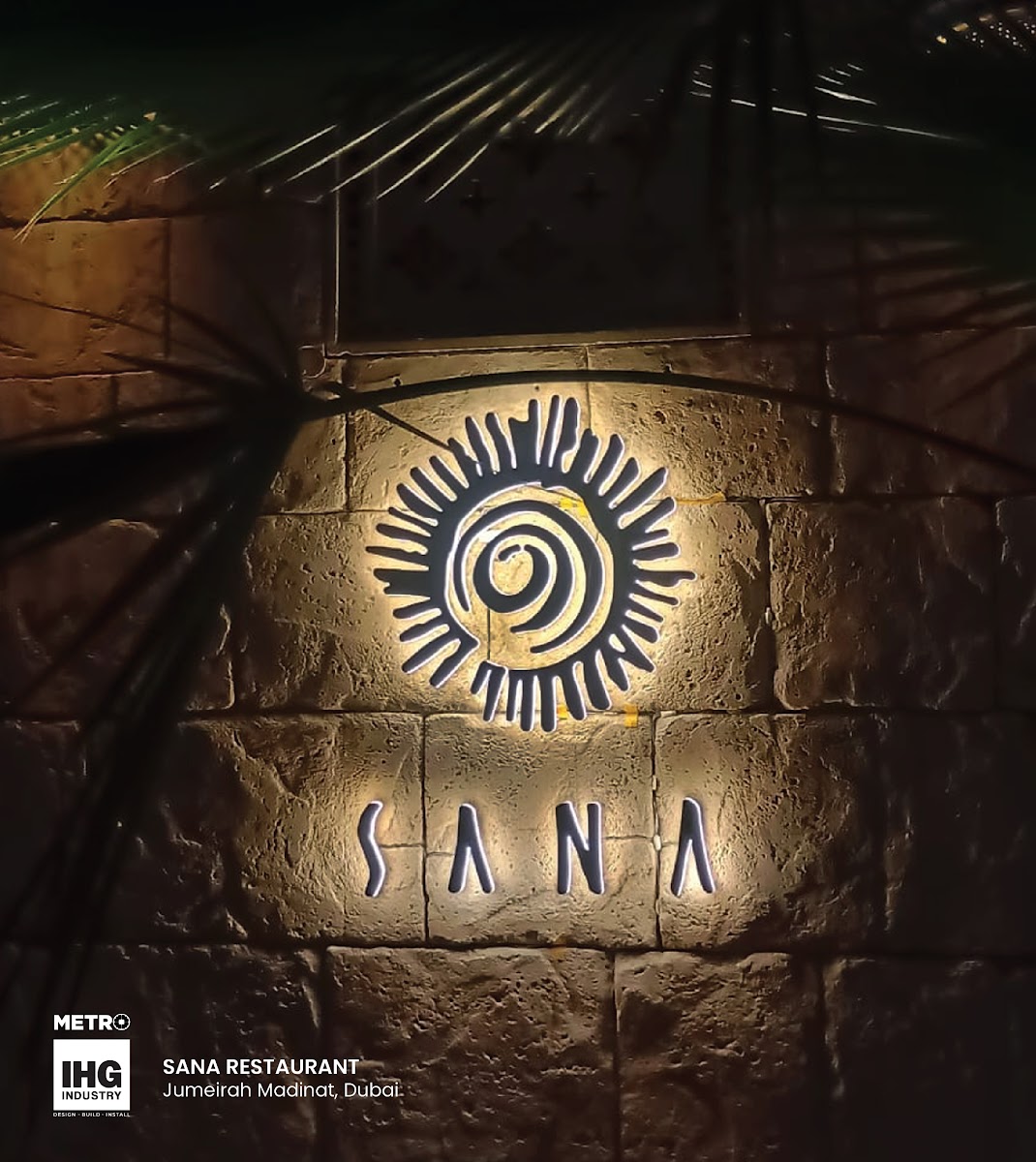 Backlit Sun-Emblem Logo on Stone Facade - Metroplus
