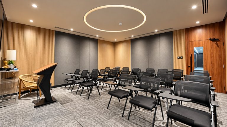 Training room with tablet-arm chairs, lectern and acoustic wall panels - Metroplus