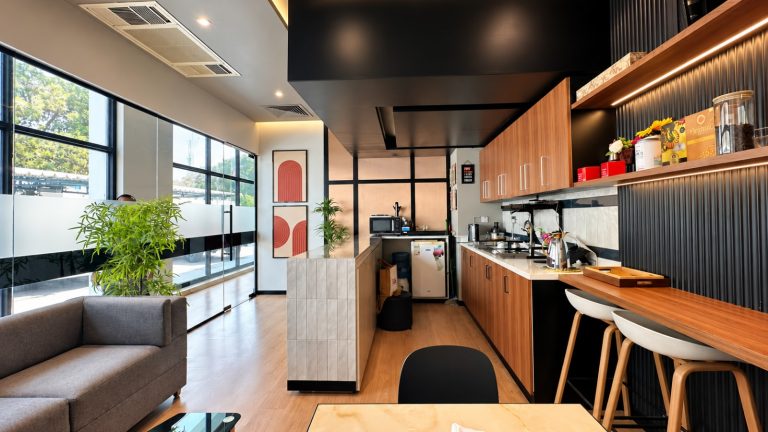 Staff pantry and lounge with timber cabinetry, fluted black wall and bar seating - Metroplus