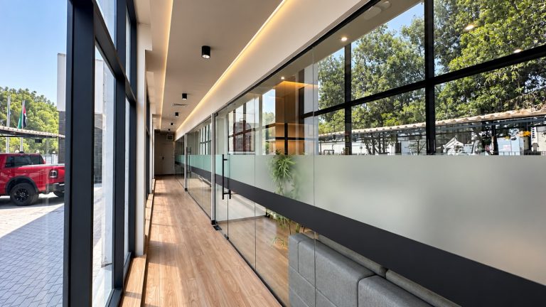 Long glazed office corridor overlooking the Metroplus Jebel Ali factory yard