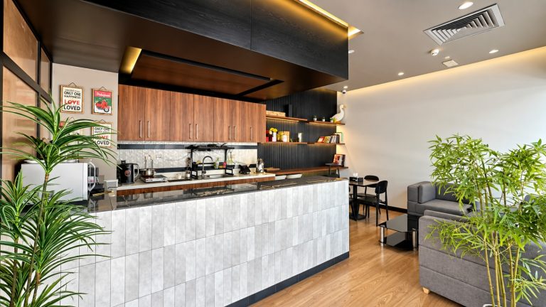 Pantry breakout counter with marble finish and wood cabinetry at Metroplus head office