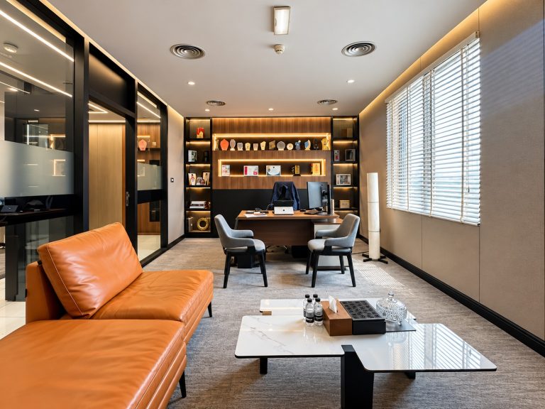 Executive office with tan leather sofa, desk and display shelving at Metroplus head office