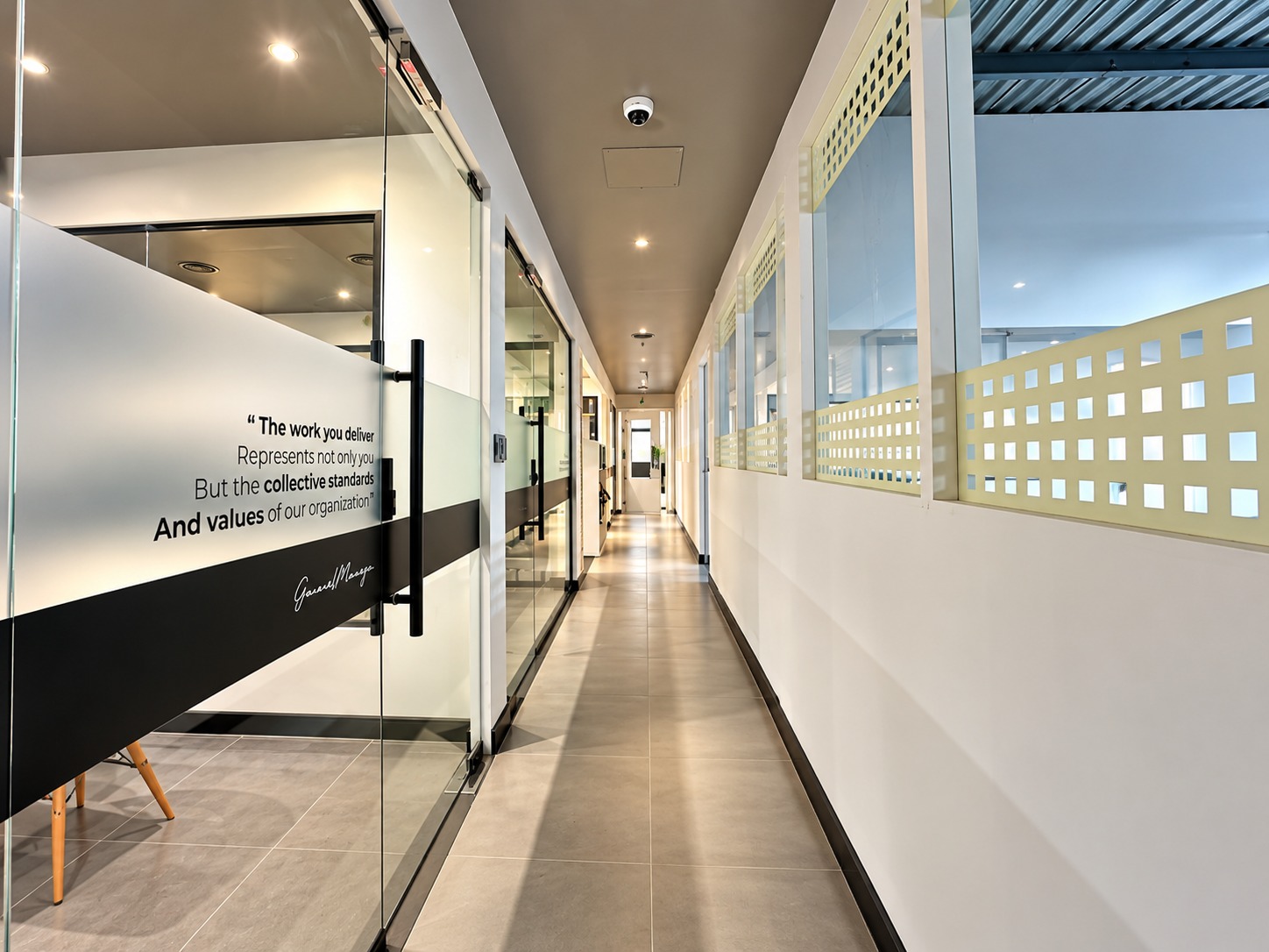 Glazed office corridor with a frosted glass values quote at the Metroplus Jebel Ali head office