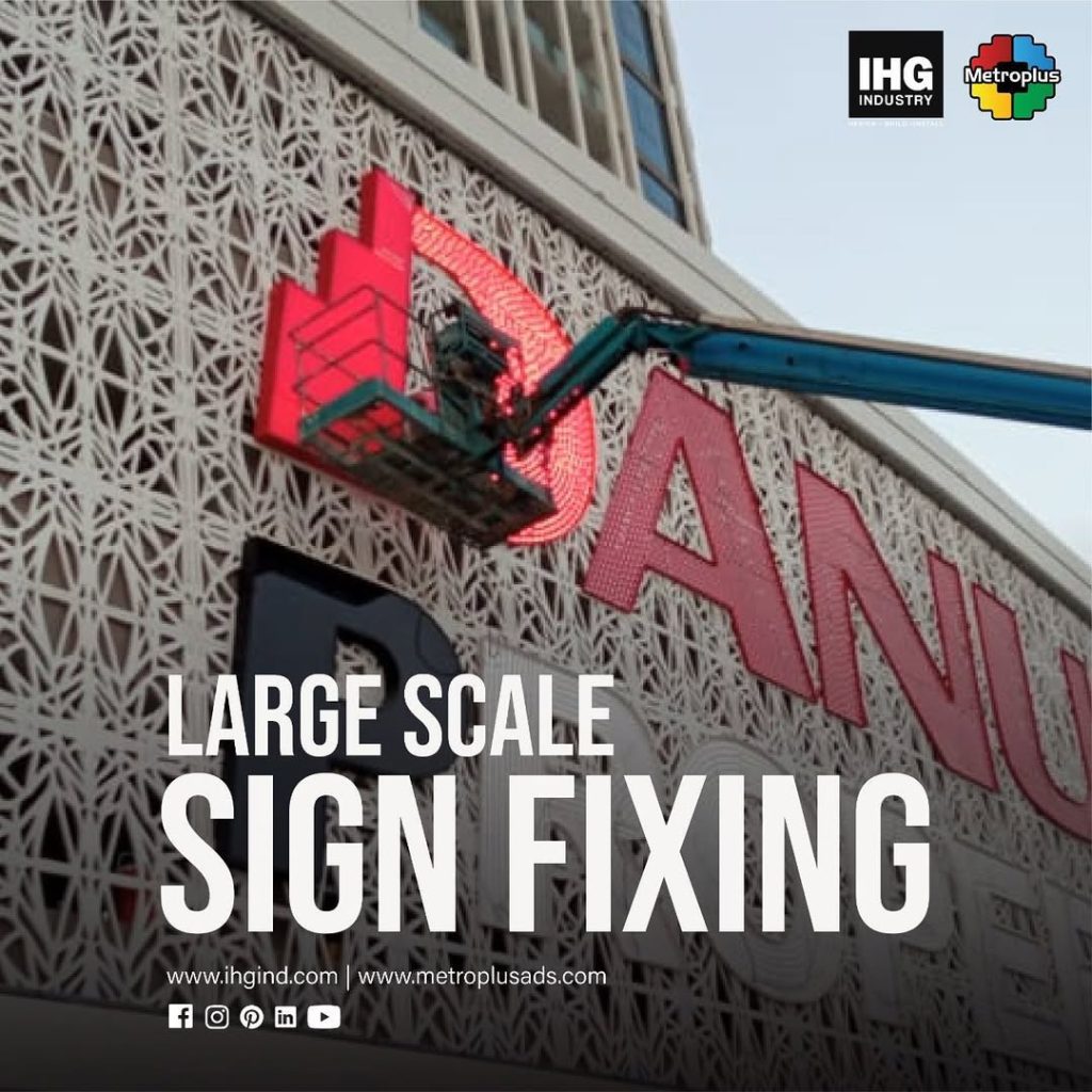 Metroplus installation team fixing large-scale signage at height