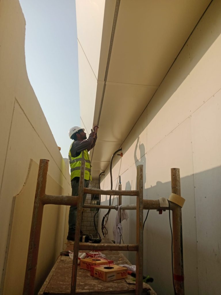 Metroplus installer fixing soffit cladding from a scaffold