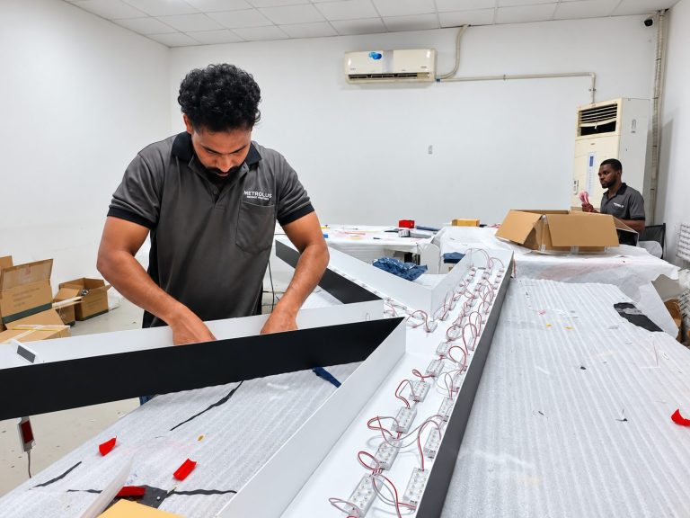 Technician fitting LED modules into a sign box at the Metroplus workshop